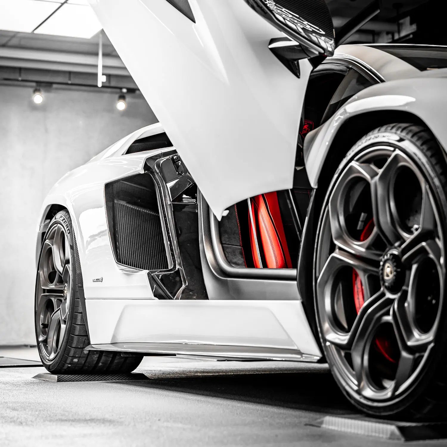 Ein weißer Sportwagen steht mit Reifen auf Reifenschuhen aus Flexigel®.