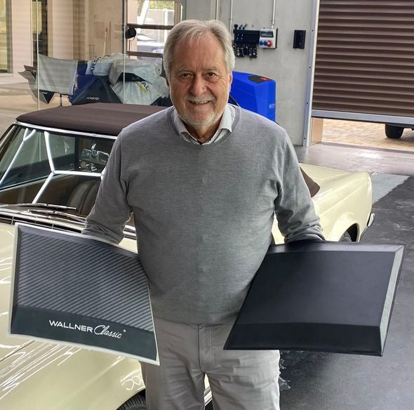 Der Erfinder der Flexigel® Reifenschoner und Gründer der Atuforma GmbH, Volker Zitt, präsentiert stolz die Reifenschoner. Hinter ihm steht ein weißer Oldtimer.