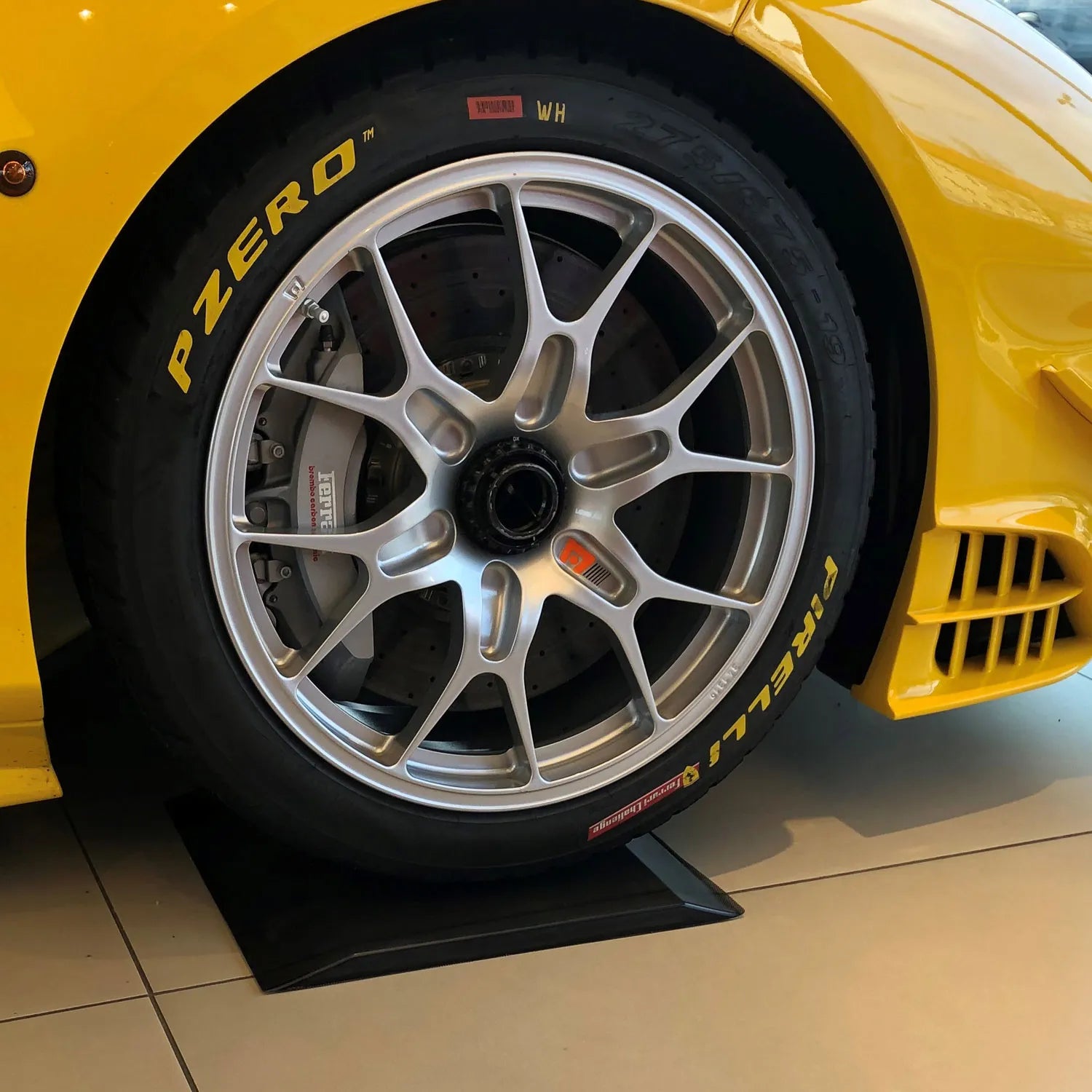 Gelber Ferrari steht auf einer schwarten Reifenwiege aus Pu-Gel.
