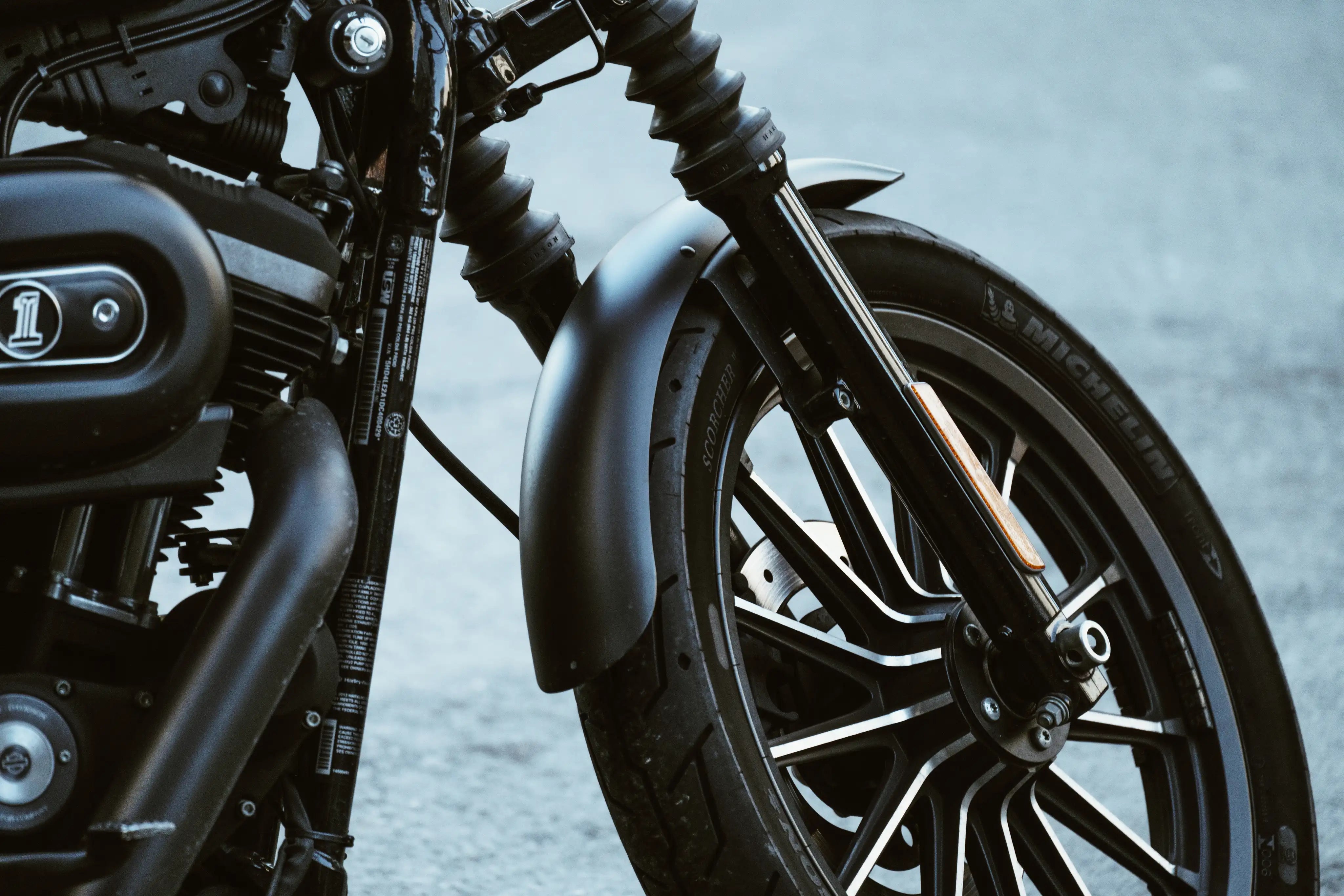 Ein schwarzes Motorrad steht im freien auf einem Reifenschoner.